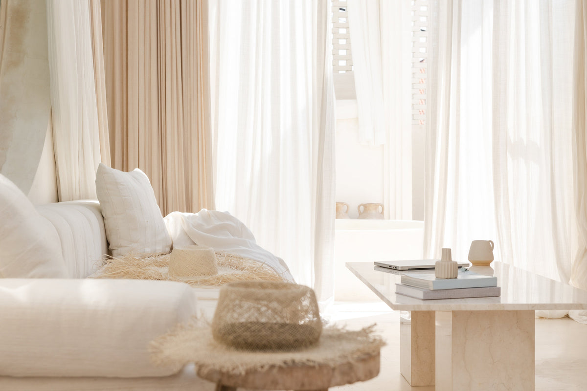 Bright living room with a cream sofa, linen curtains and a low timber coffee table