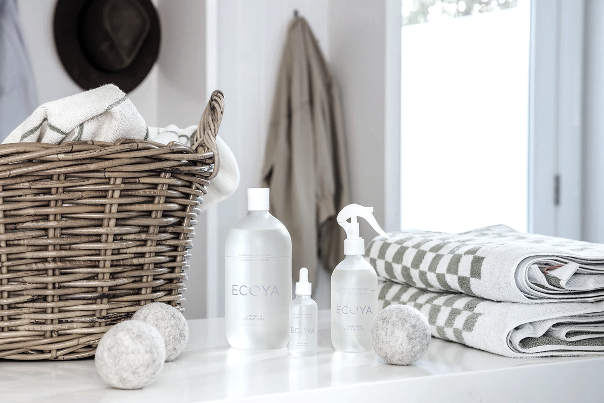 Laundry with a wicker basket, Ecoya laundry bottles, wool dryer balls and folded checked towels