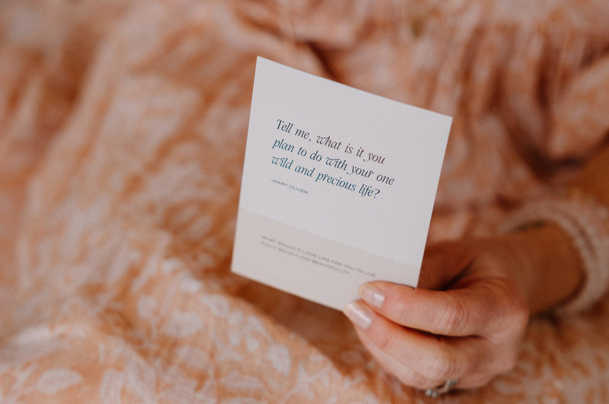 Affirmation card held against a soft pink knit