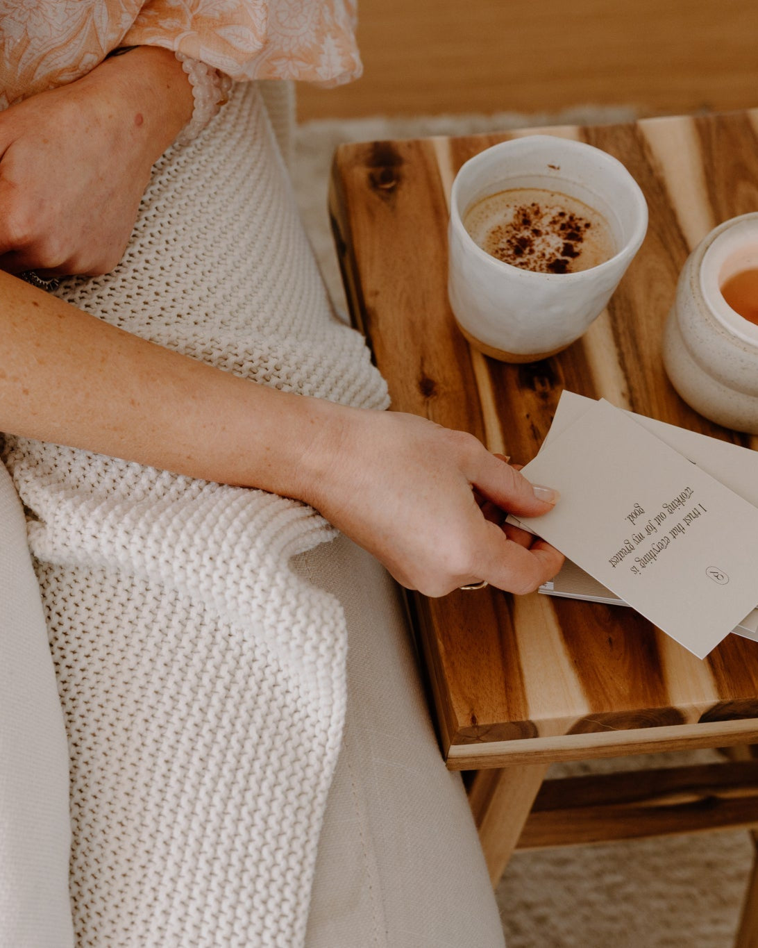 Person holding a card beside a bowl on a timber tray