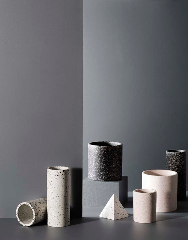 A group of Zakkia Terrazzo Pots - Black with minimalist design on a grey surface.