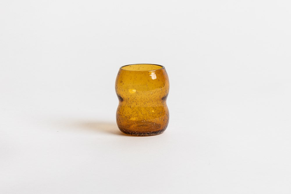 Como tumbler shown in a deeper amber colour not sold on this listing, on a white backdrop