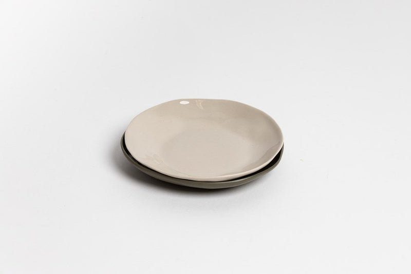The Ned Collections Haan Round Dish, made of stoneware, showcases an organic feel with its white surface and black rim.