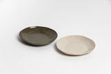 Two Haan Round Dish plates on a white surface.