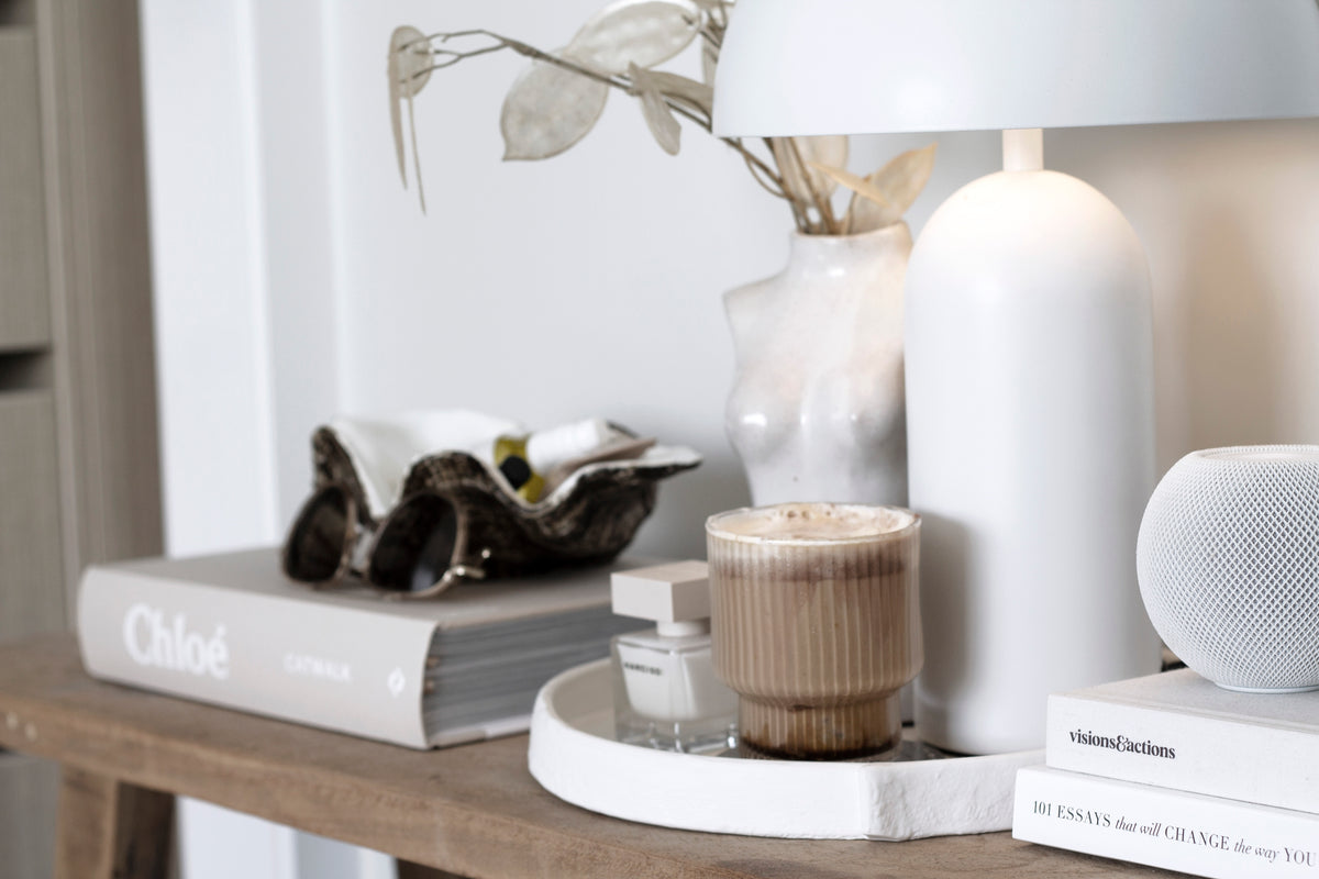 Burlap tray with a coffee, a candle and a silver dish on a timber console