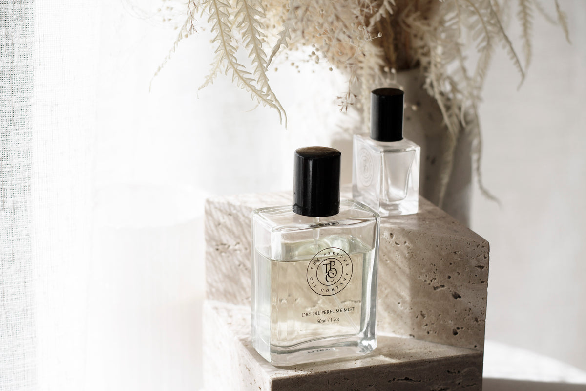 Roll-on perfume oil bottle beside a vase of dried grasses