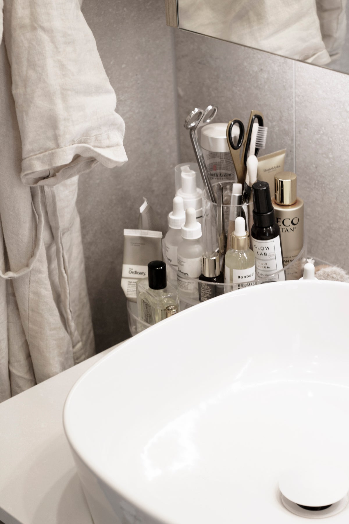 Umbra Cascada organiser beside a basin holding brushes, tools and skincare