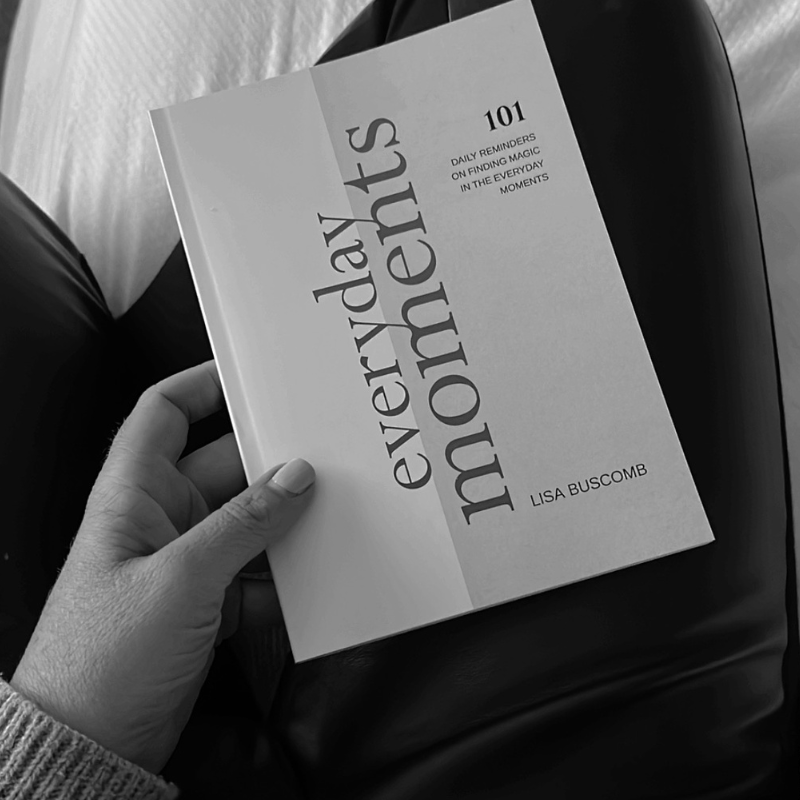 A black and white photo capturing an EVERYDAY MOMENTS Book, with a person lovingly holding a book by Lisa Buscomb.