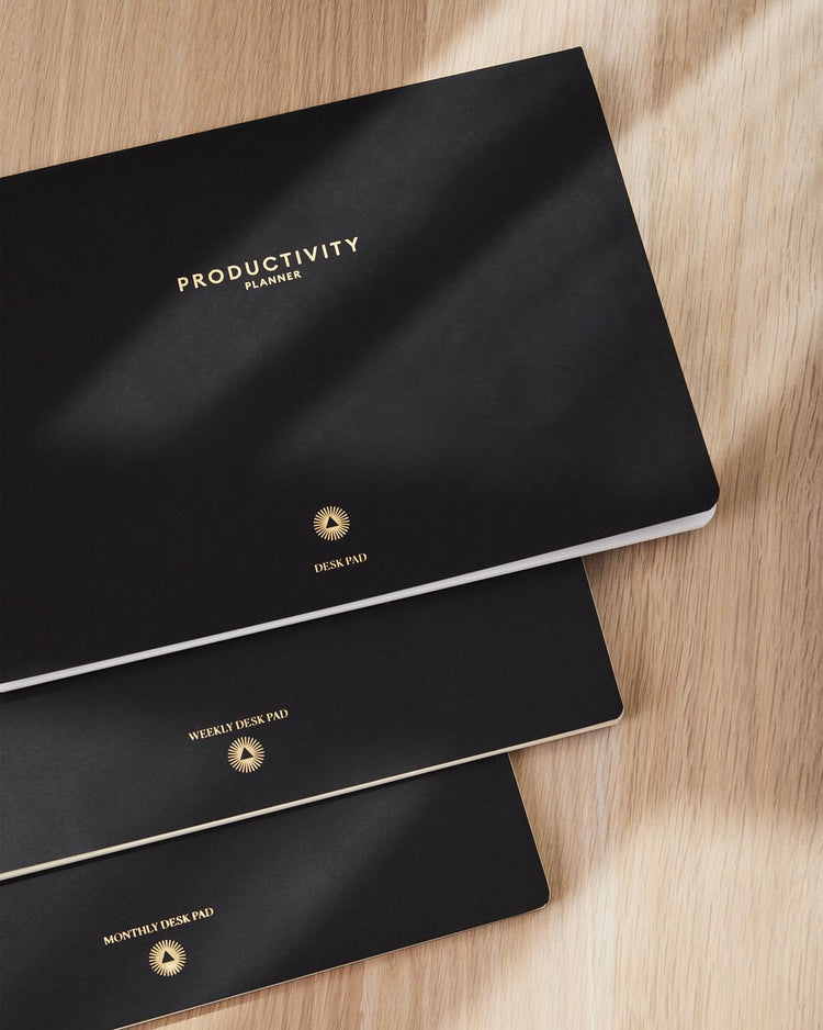 Productivity Weekly Desk Pad styled with a pen and coffee cup