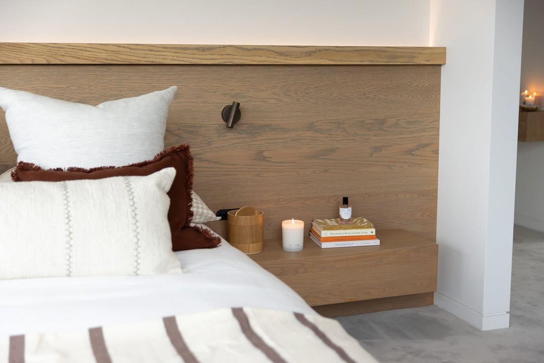 Bedroom with a timber bedhead and an Ecoya room spray on the bedside shelf