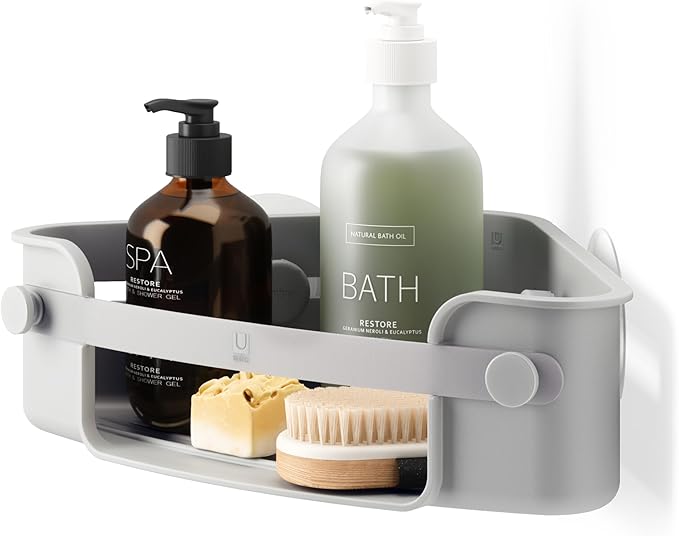 Umbra Flex adhesive corner bin in grey holding bath bottles, soap and a brush