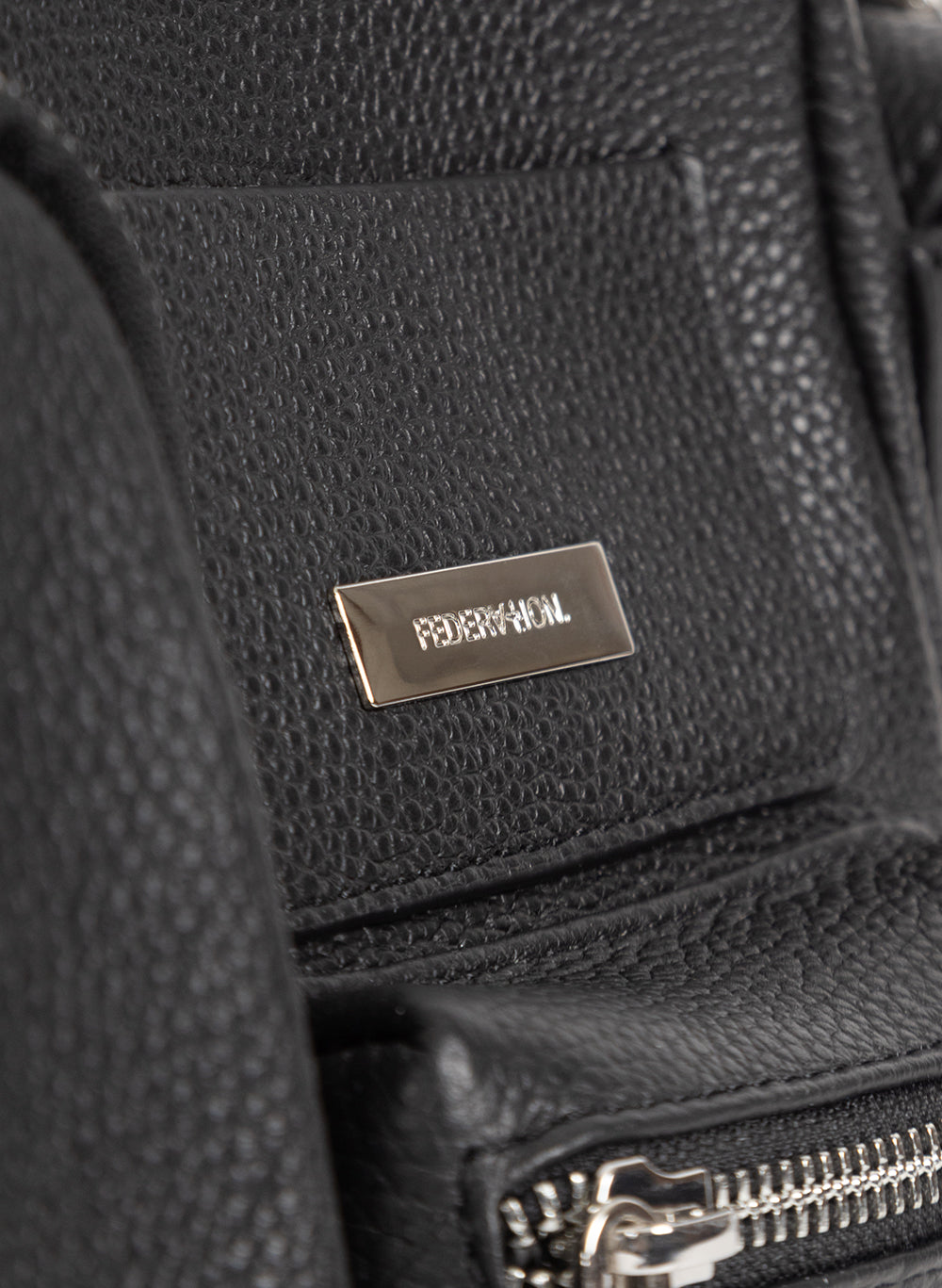 Close-up of the silver Federation logo plate on the black leather