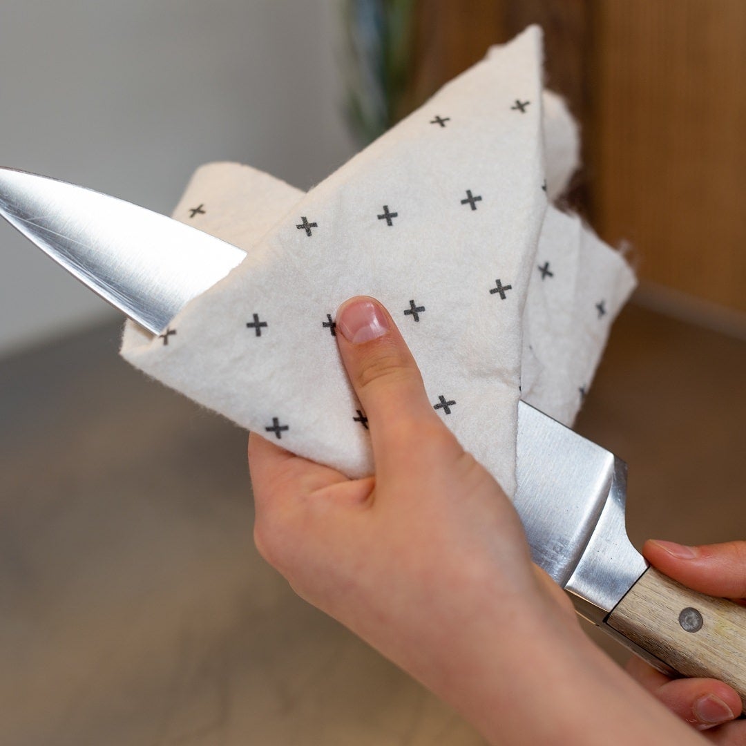 Good Change reusable bamboo towel being used to clean a knife