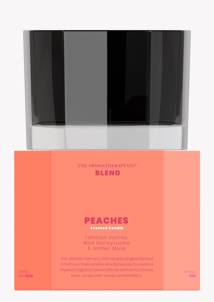 Blend Peaches scented candle in black glass stacked on its coral box