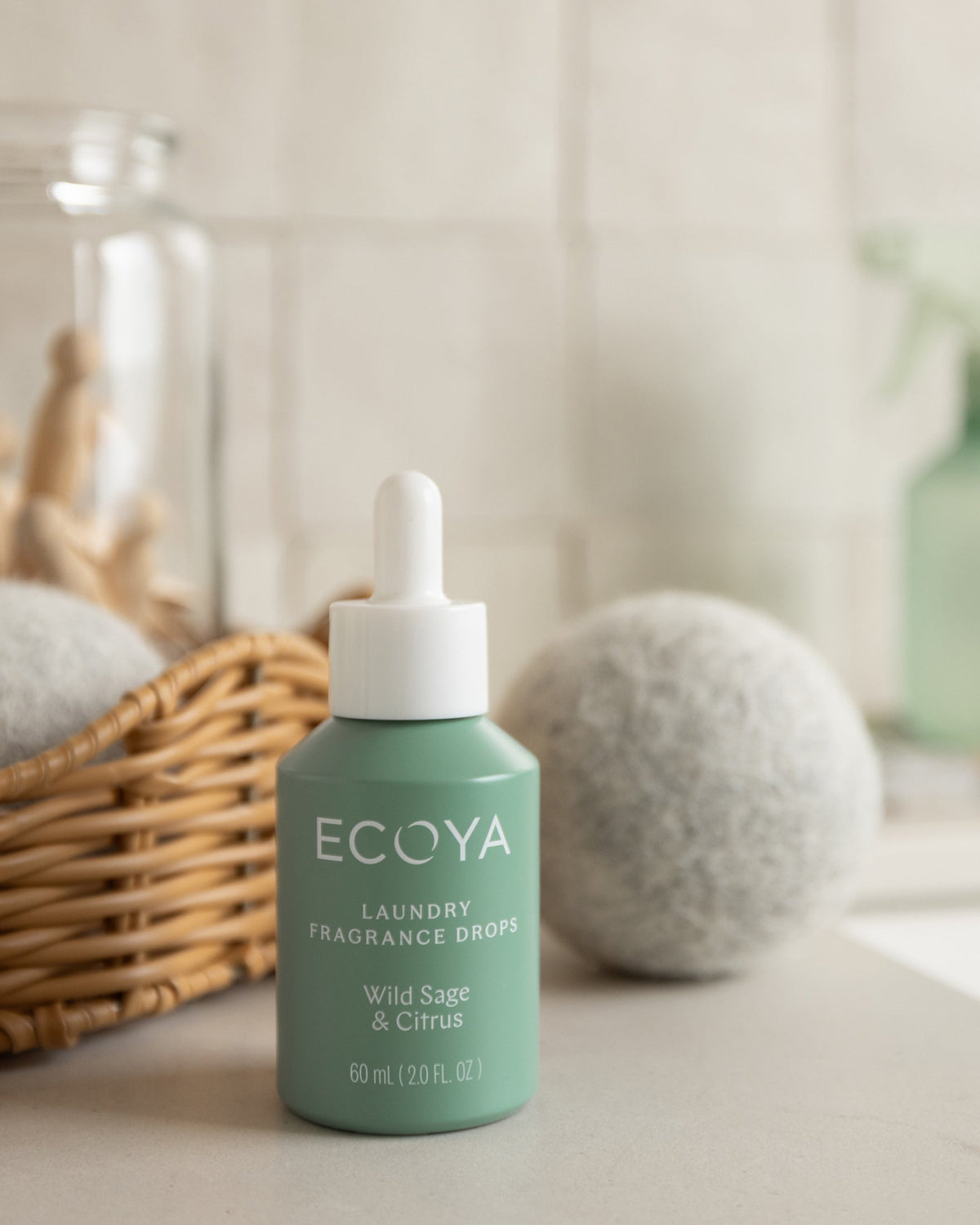 Ecoya Wild Sage and Citrus fragrance drops styled in a laundry with wool dryer balls