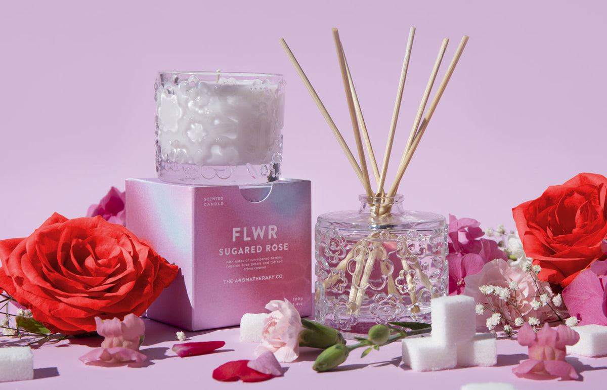 The Sugared Rose diffuser, candle and carton together with red roses and sugar cubes