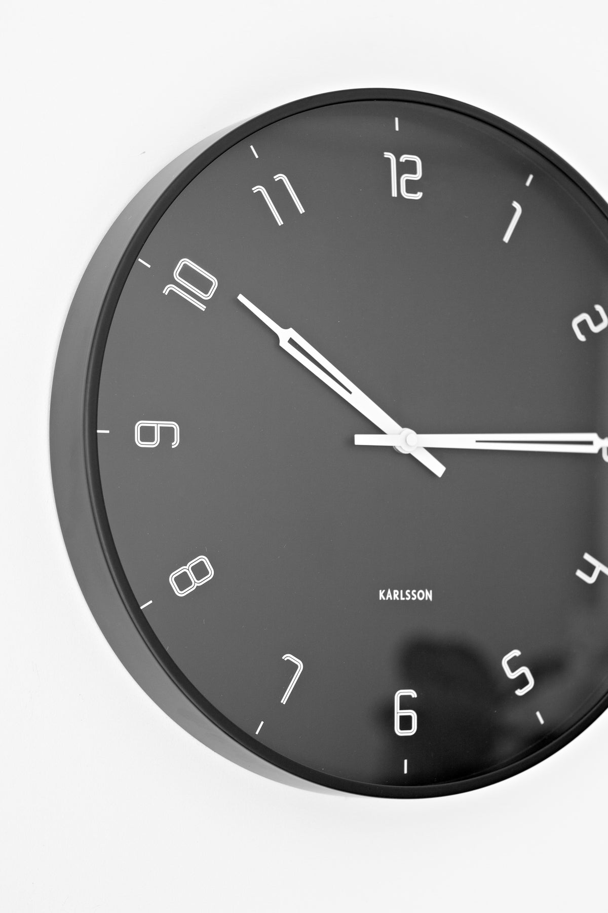 Black Stark wall clock seen from the side, showing its slim rim