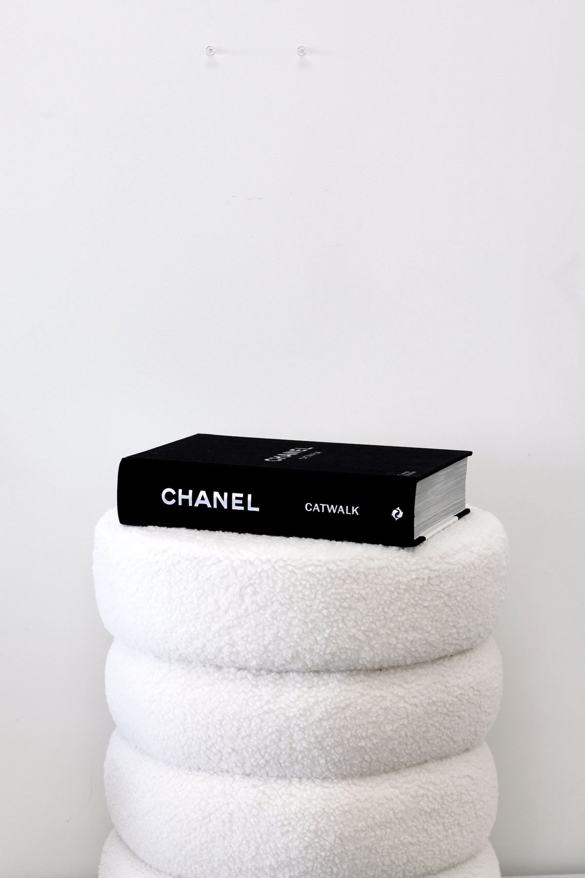 Chanel Catwalk book resting on a white boucle stool