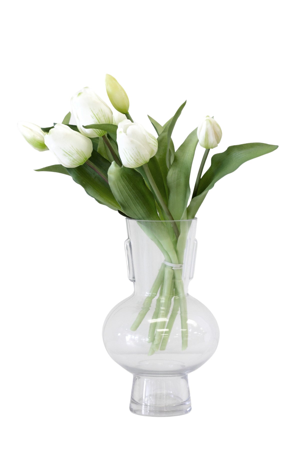 White faux tulip bouquet in a clear glass bud vase on a white background