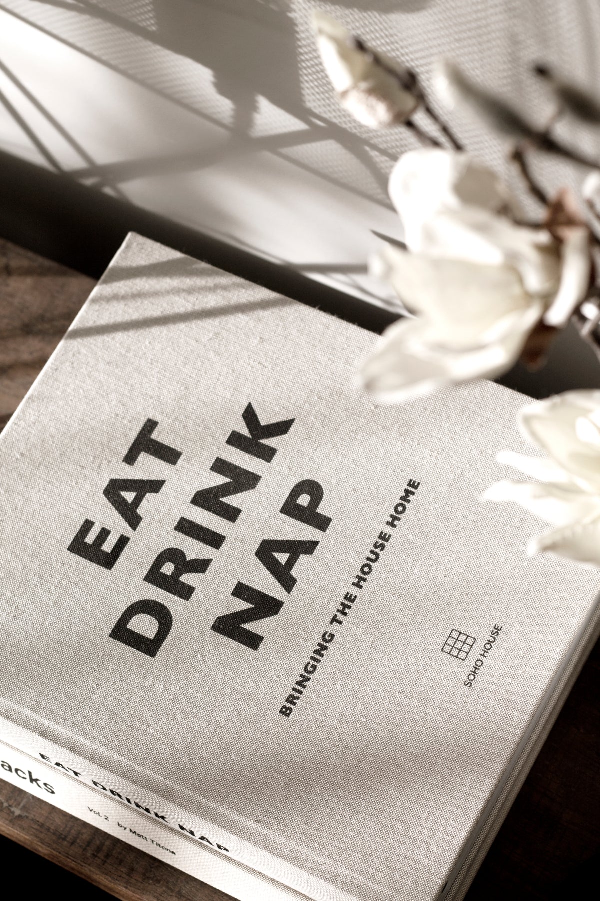 Eat, Drink, Nap book at an angle on a linen surface