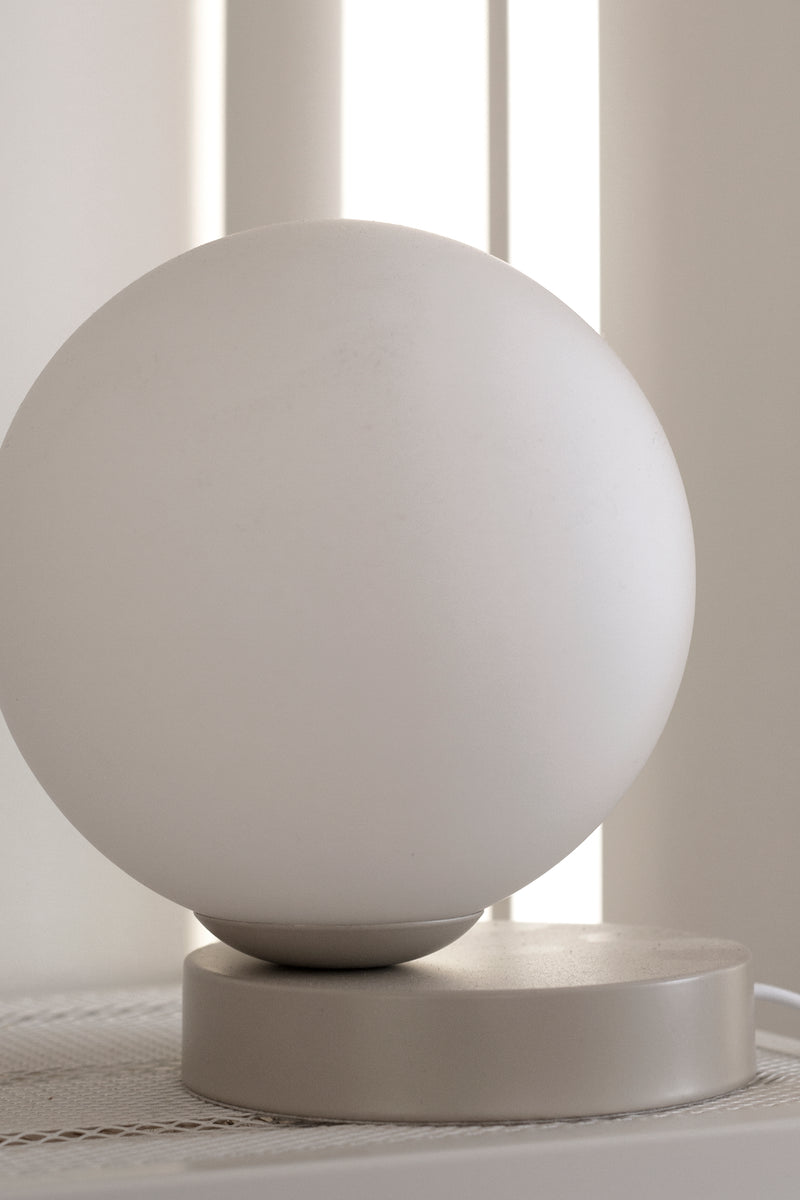 A Yuri table lamp from Ned Collections sitting on top of a table.