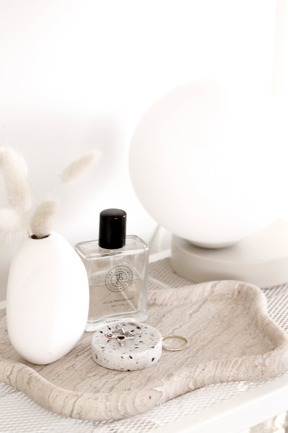 An elegant tray adorned with a Yuri Table lamp from Ned Collections, emitting a soft glow.