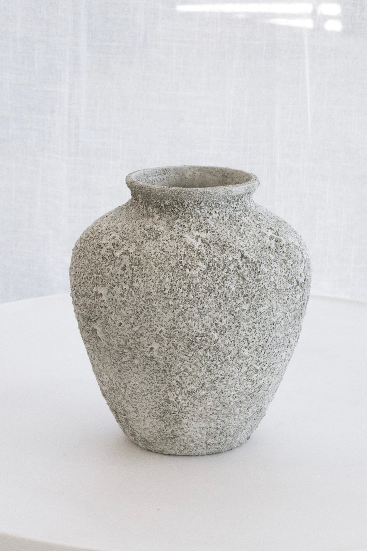 Nerina sage stone vase on a white table in soft window light