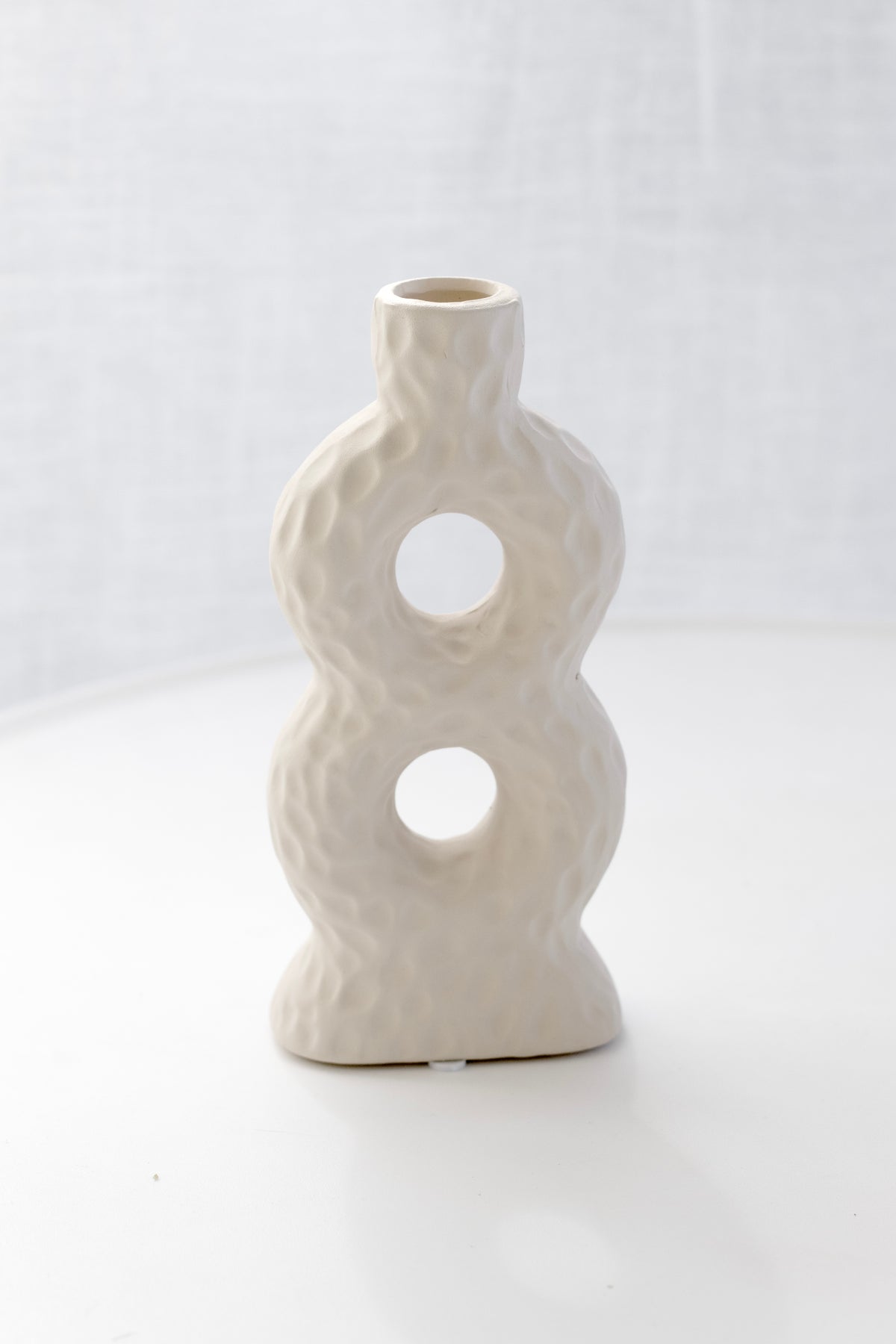 Sicily Loop Ceramic Vase alone in soft light against a sheer curtain
