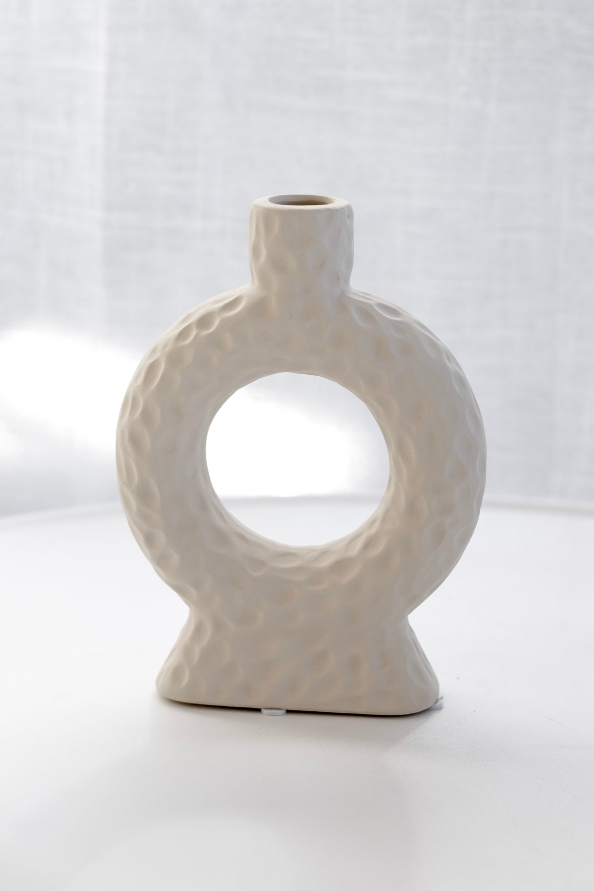 Naples Loop Ceramic Vase alone against a sheer curtain in soft light