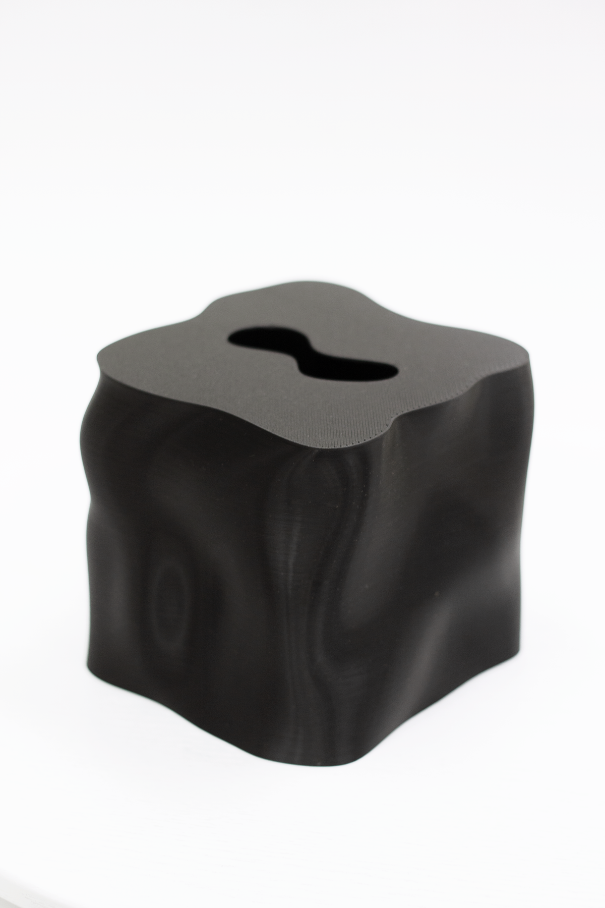 Ebb tissue box cover in black, showing the wavy sculptural form and shaped opening