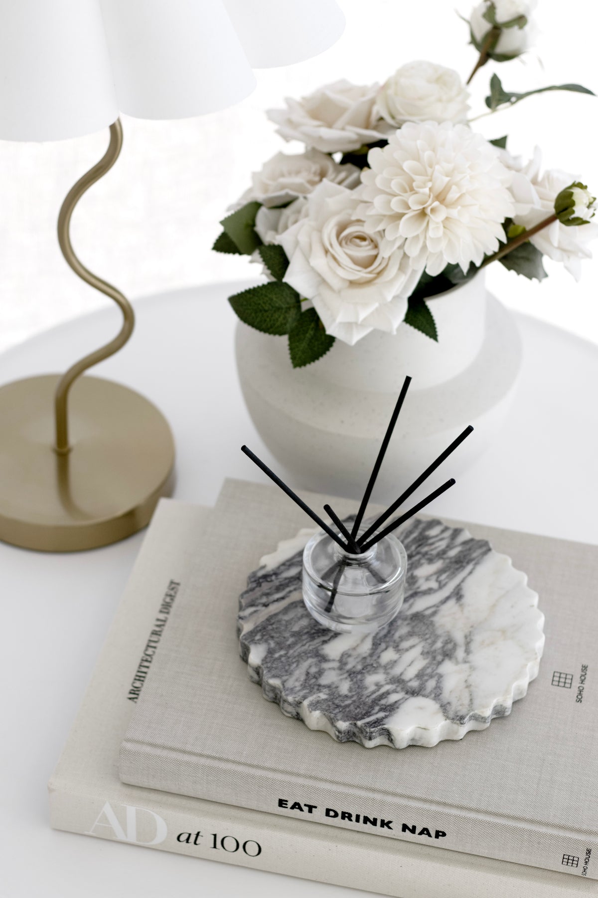 Architectural Digest at 100 styled with a candle and vase