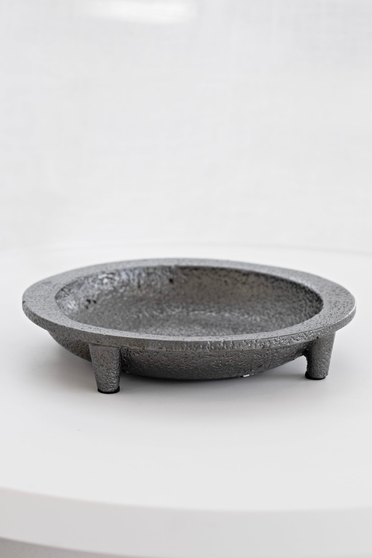Friars cement tripod plate in speckled grey on a white surface, showing its three feet