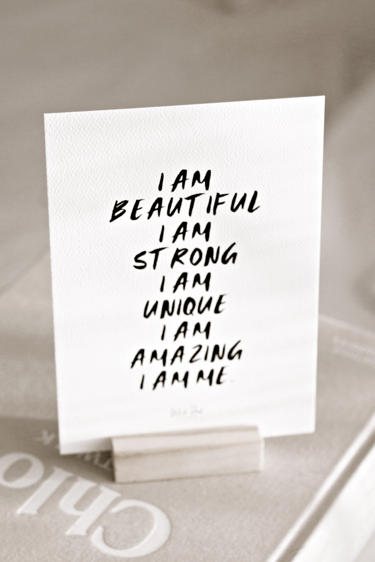 Card on a wooden stand reading I am beautiful, I am strong, I am unique, I am amazing