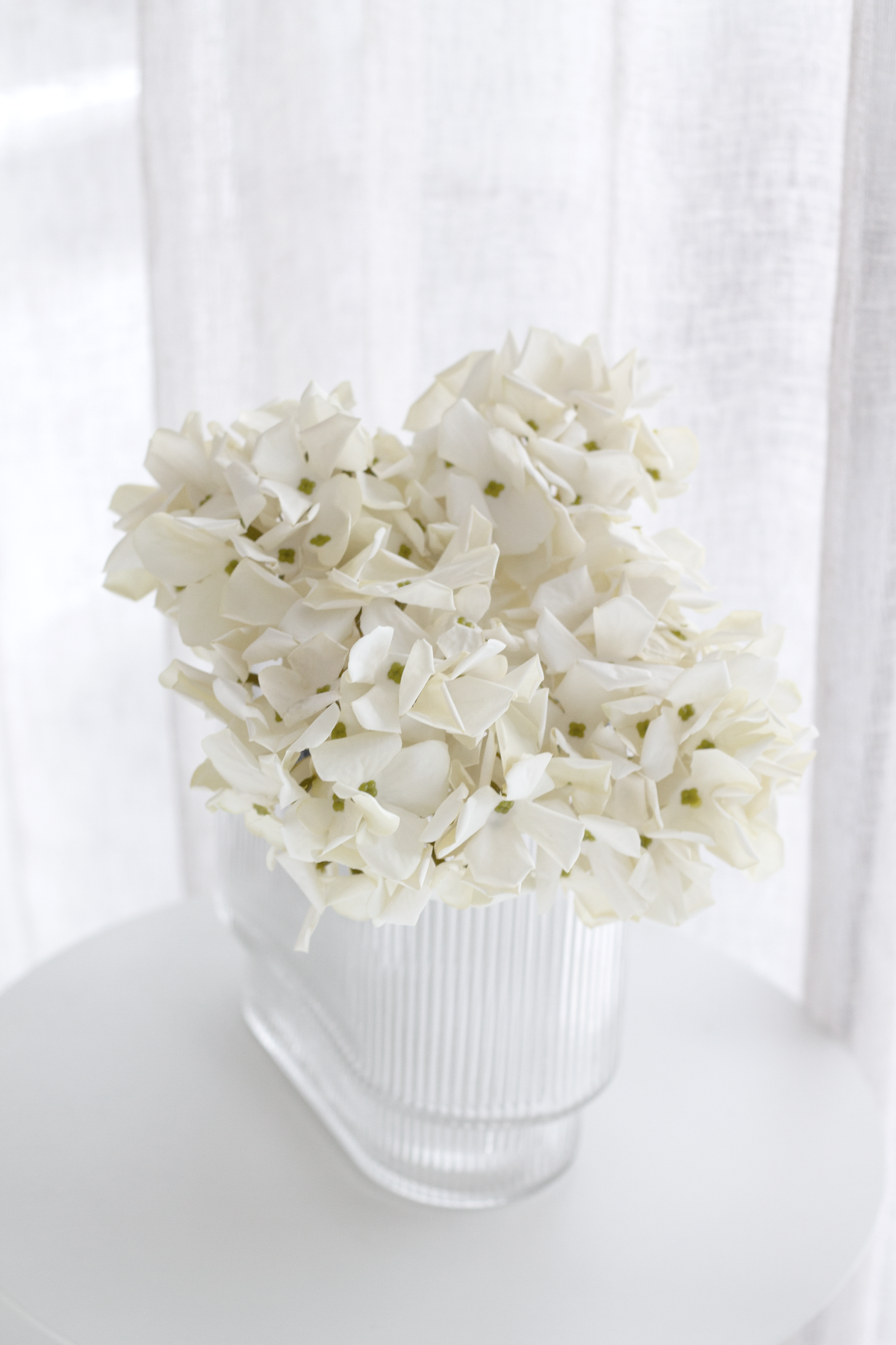 Petite faux hydrangea stems grouped in a ceramic vase