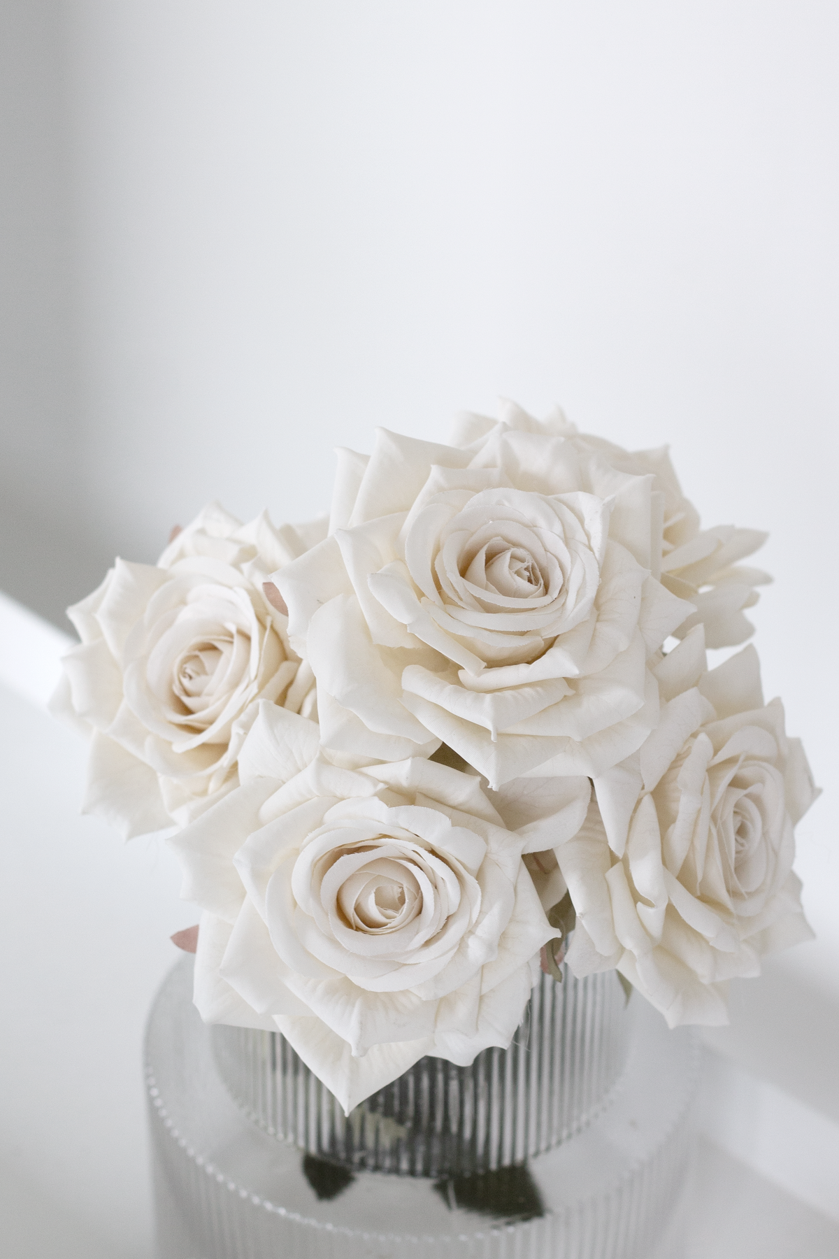 Champagne roses in a ribbed glass vase, close view