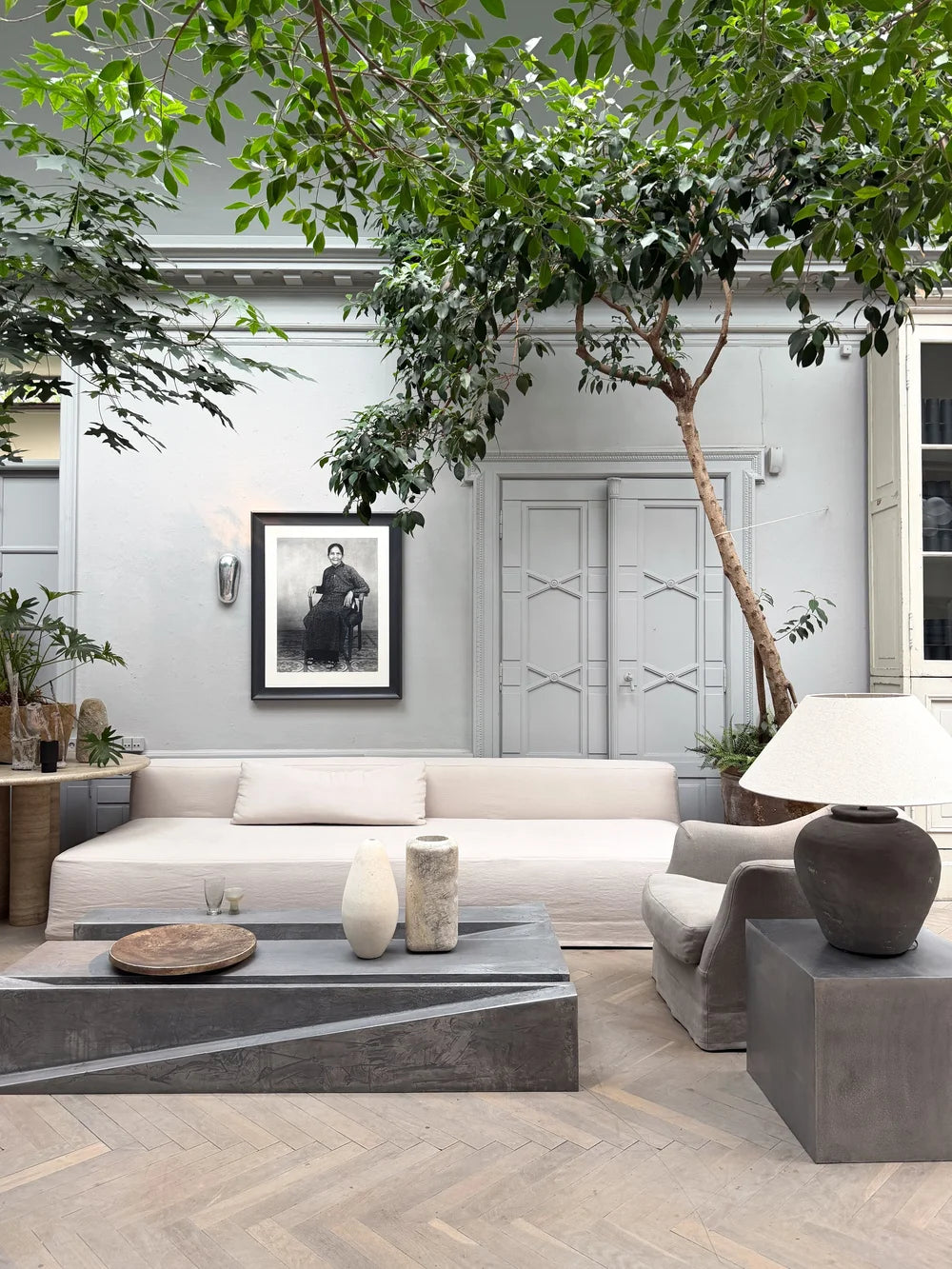 Courtyard living room with a white sofa beneath a tree