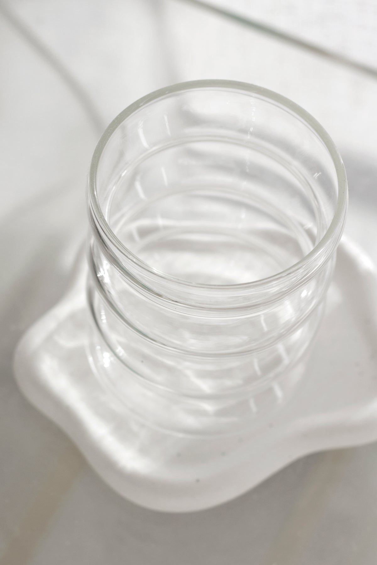Rippled glass tumbler detail showing the segmented caterpillar texture in clear glass