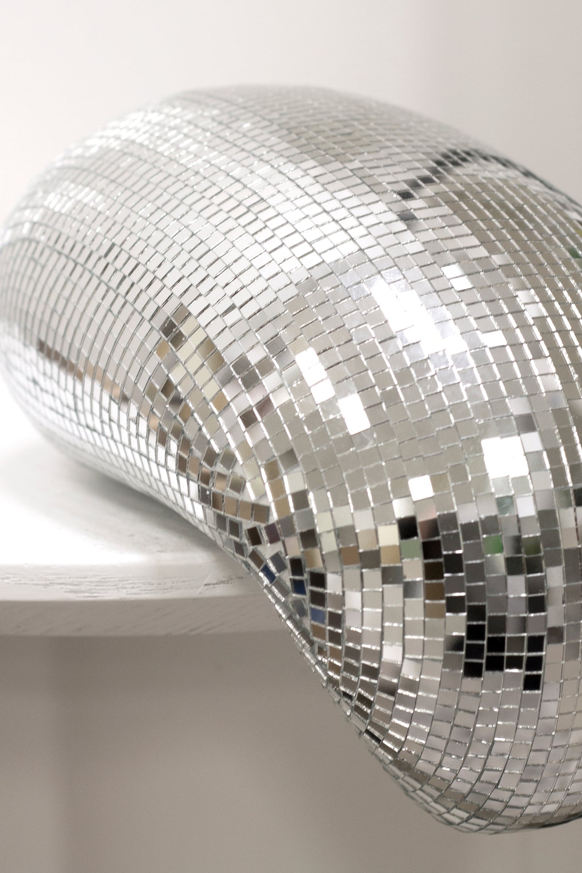 Close view of the melting disco ball showing individual mirror tiles