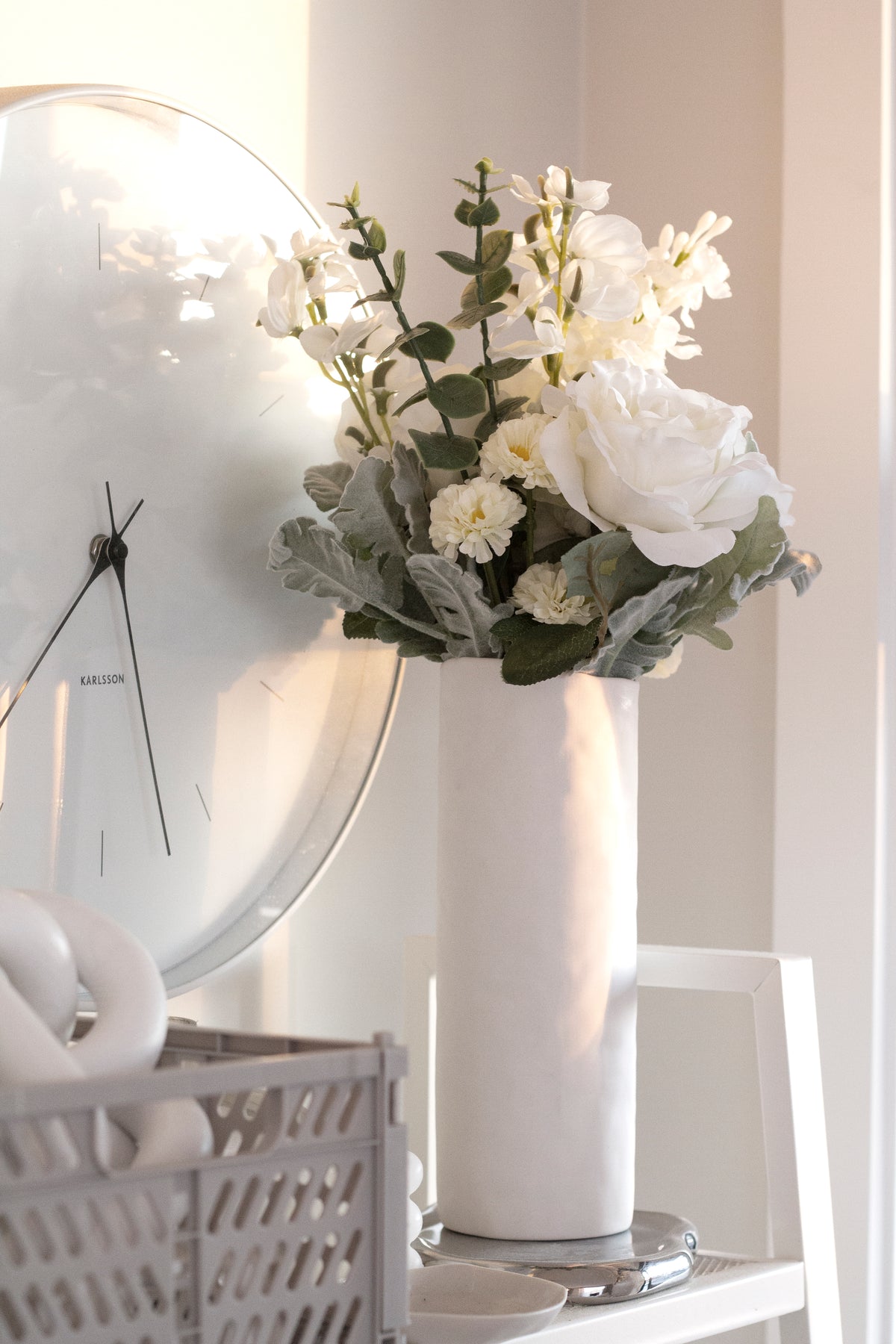 White faux bouquets in two vases on a windowsill