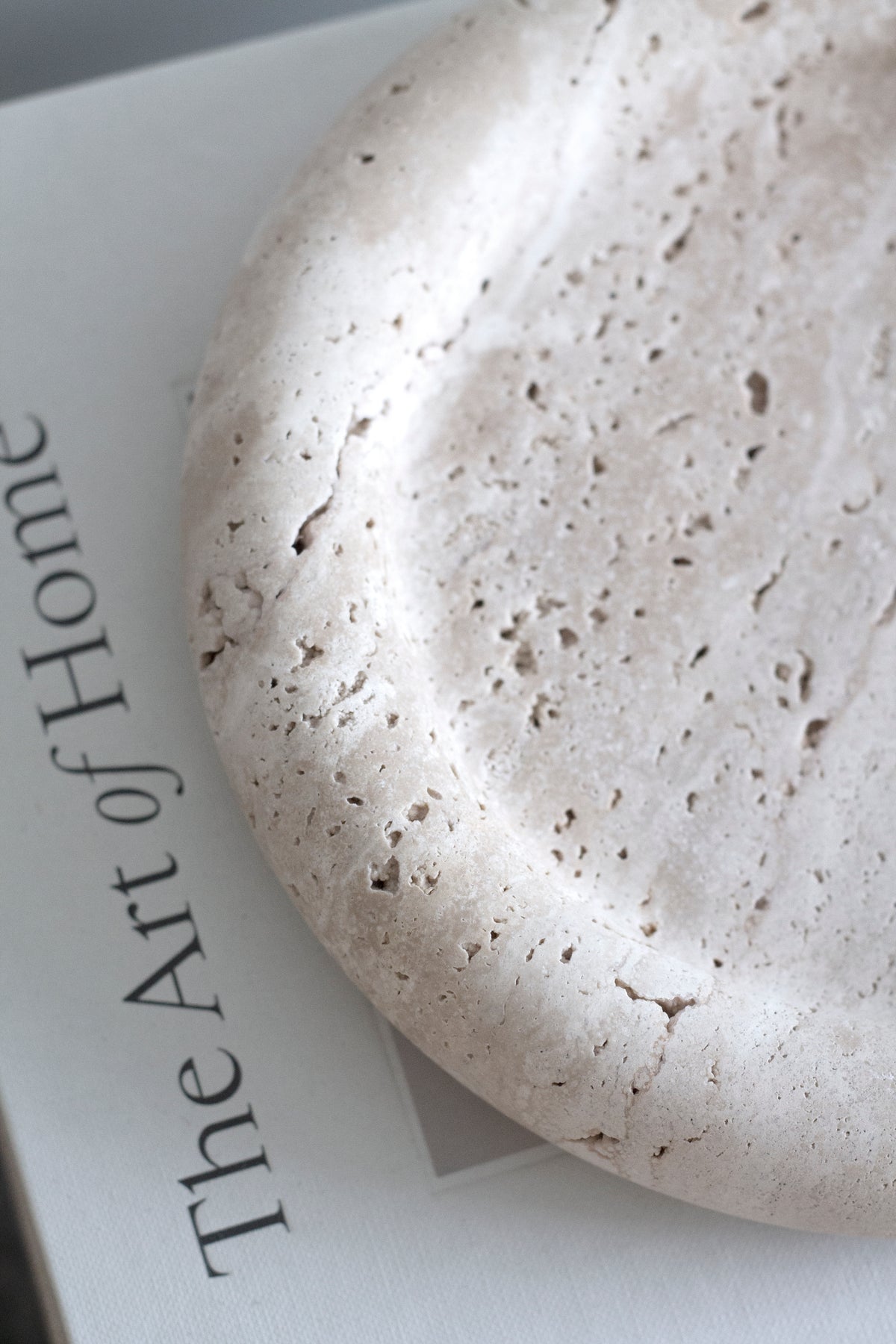Close-up of the Bay Round Tray showing natural pits and veining in the travertine