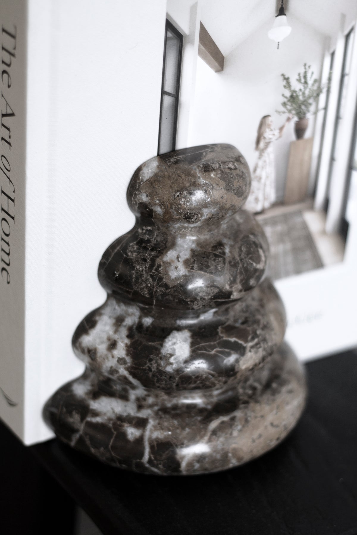 Close view of a Casa bookend beside books, marble veining visible