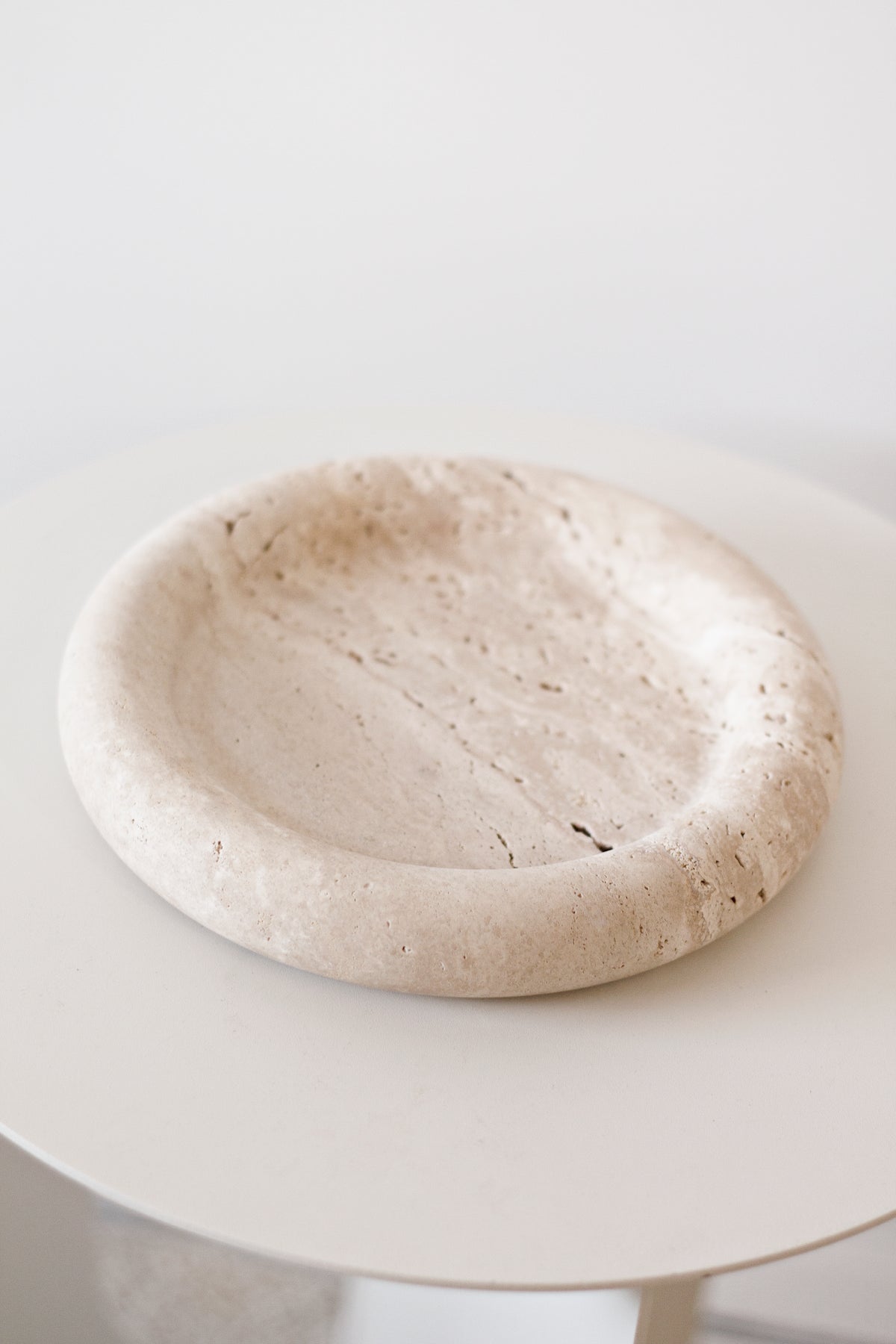 Bay Round Tray in light travertine on a round white side table