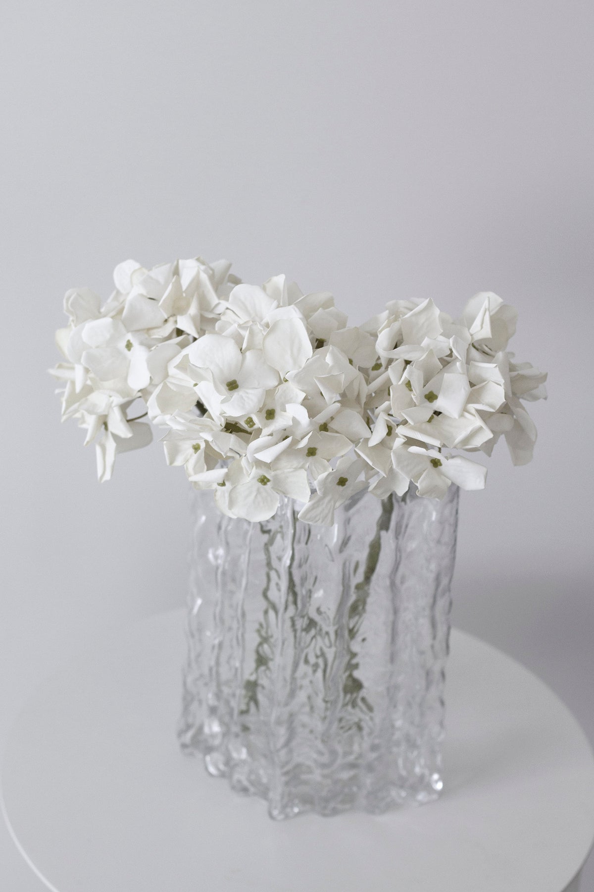 Petite faux hydrangea stems styled on a shelf