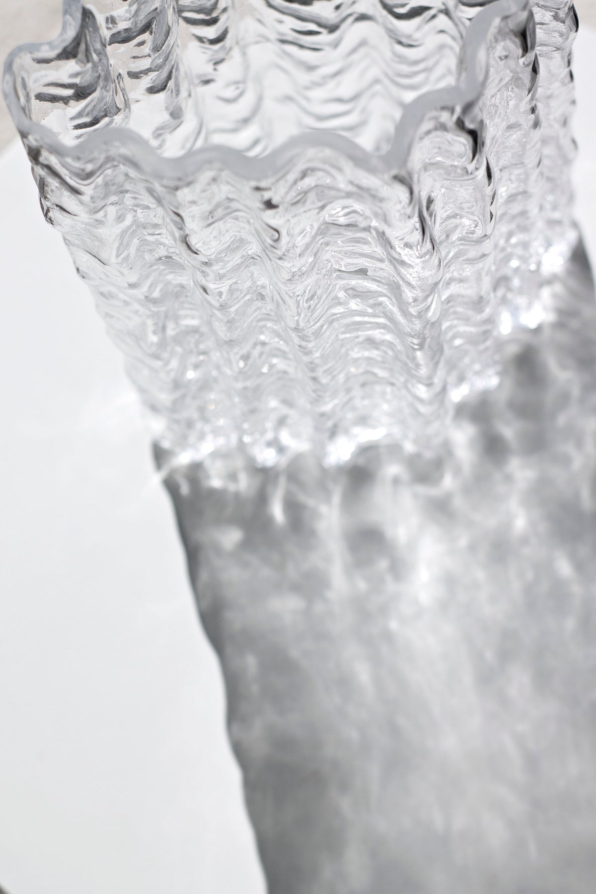 Close up of the clear Glacier rim and water line against a bright background
