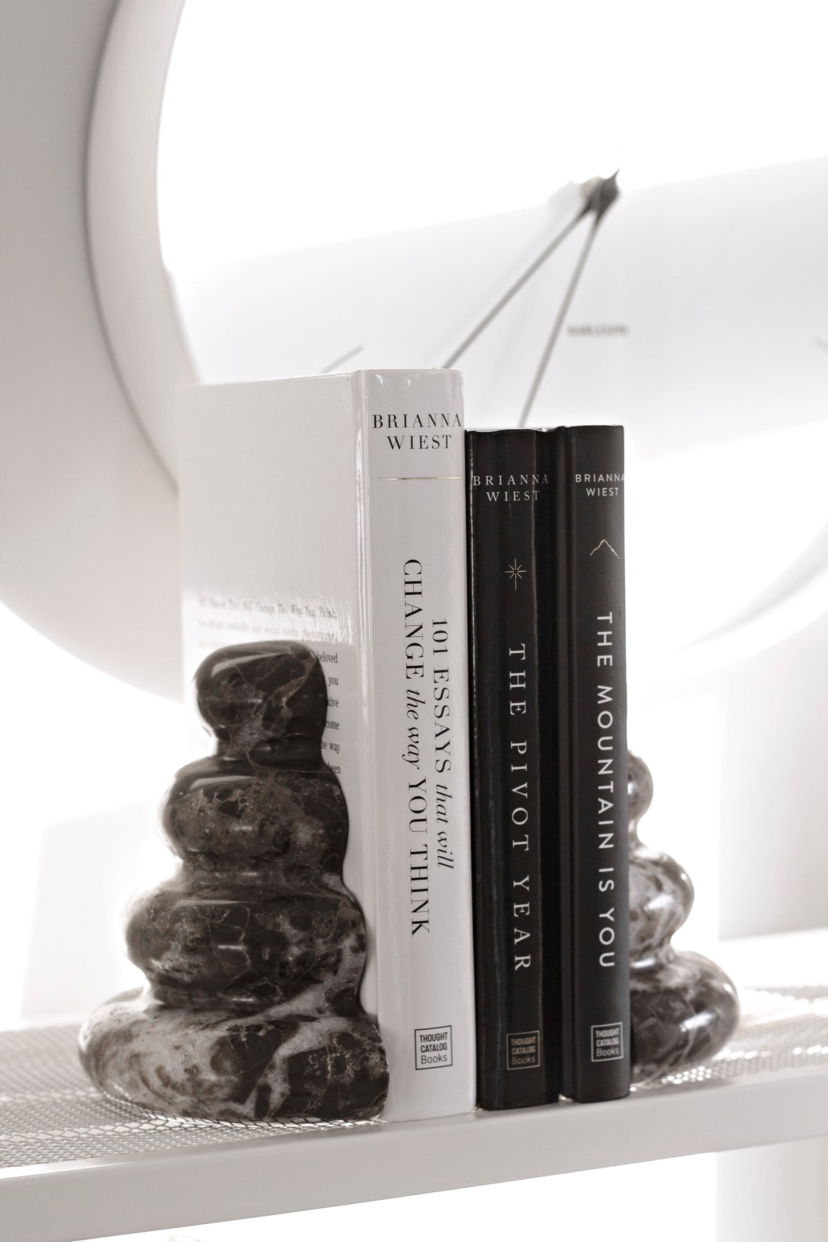 Casa bookend holding books on a white table in sunlight