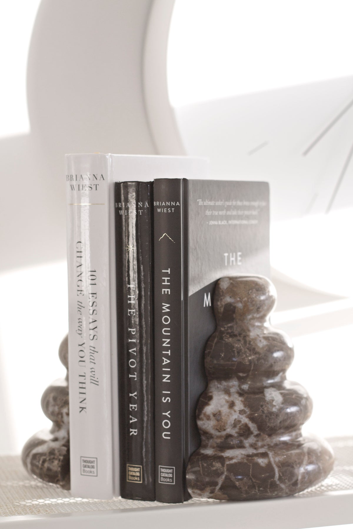 Casa bookends holding books on a white table, angled view