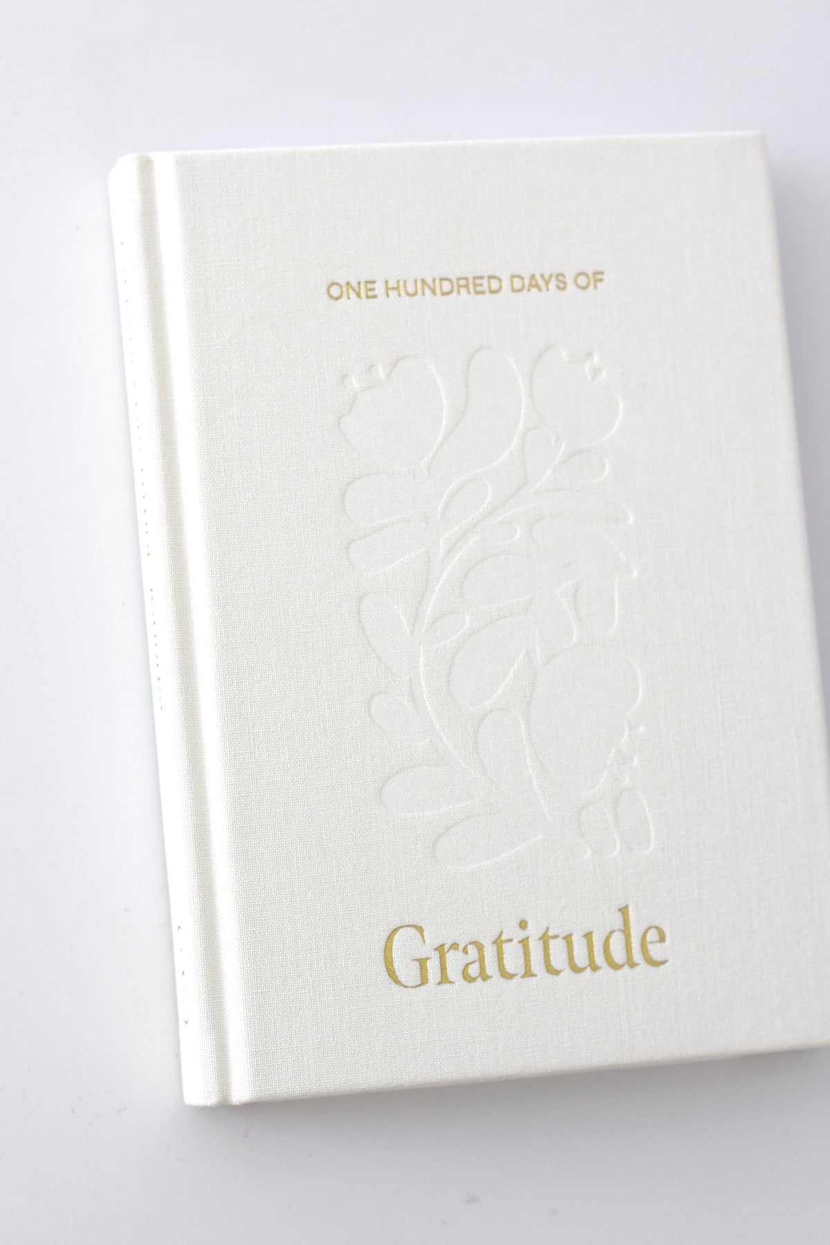 Angled view of the linen hardcover with debossed floral design