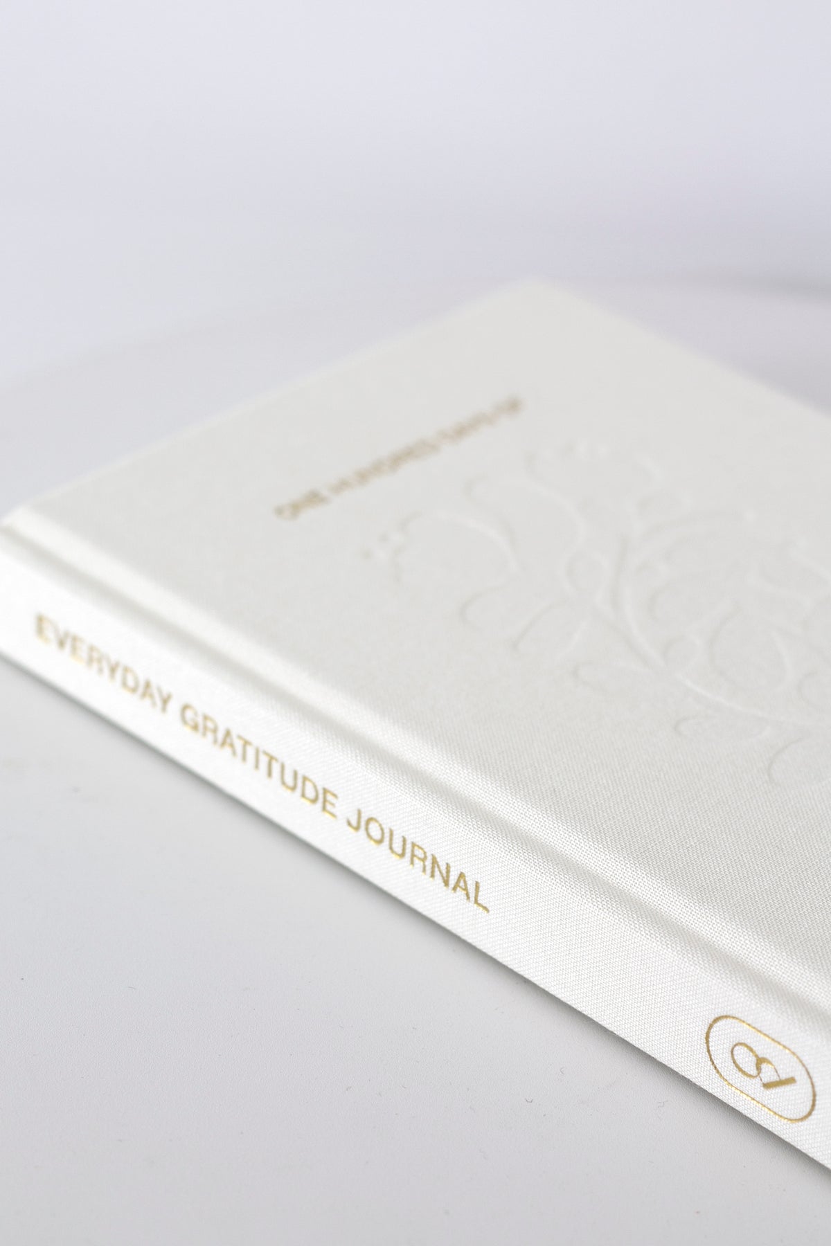 Closed gratitude journal lying at an angle, showing the gold title on the spine