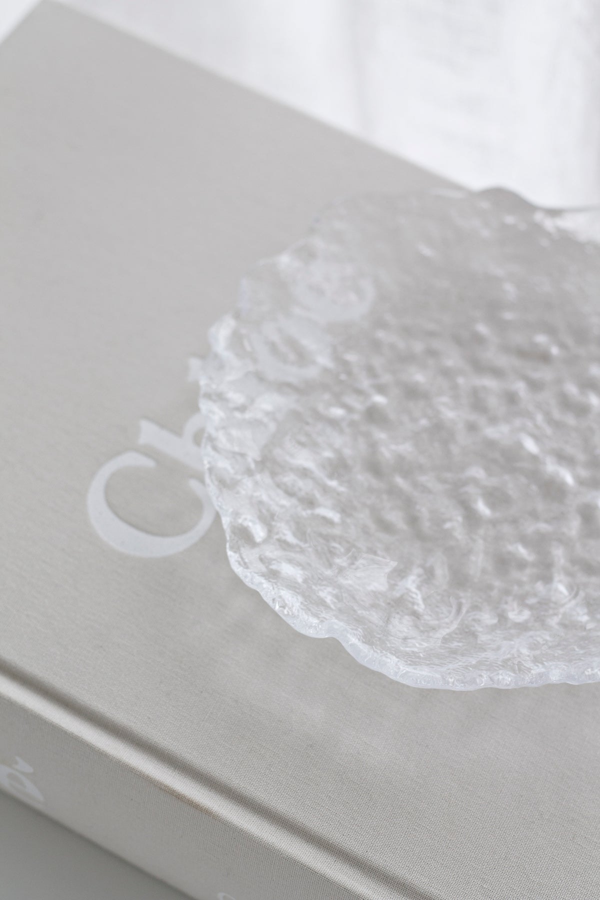 Close view of the Glacier glass tray on books, showing the bubble texture