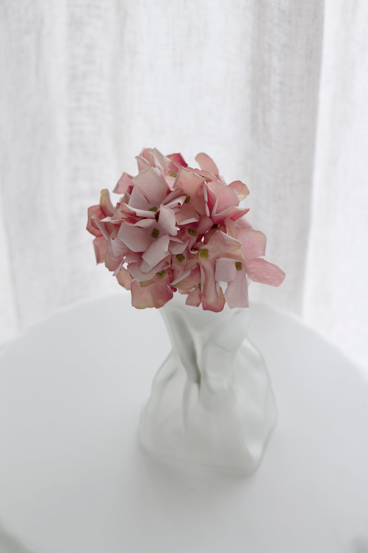Petite faux hydrangea stem layered in an arrangement